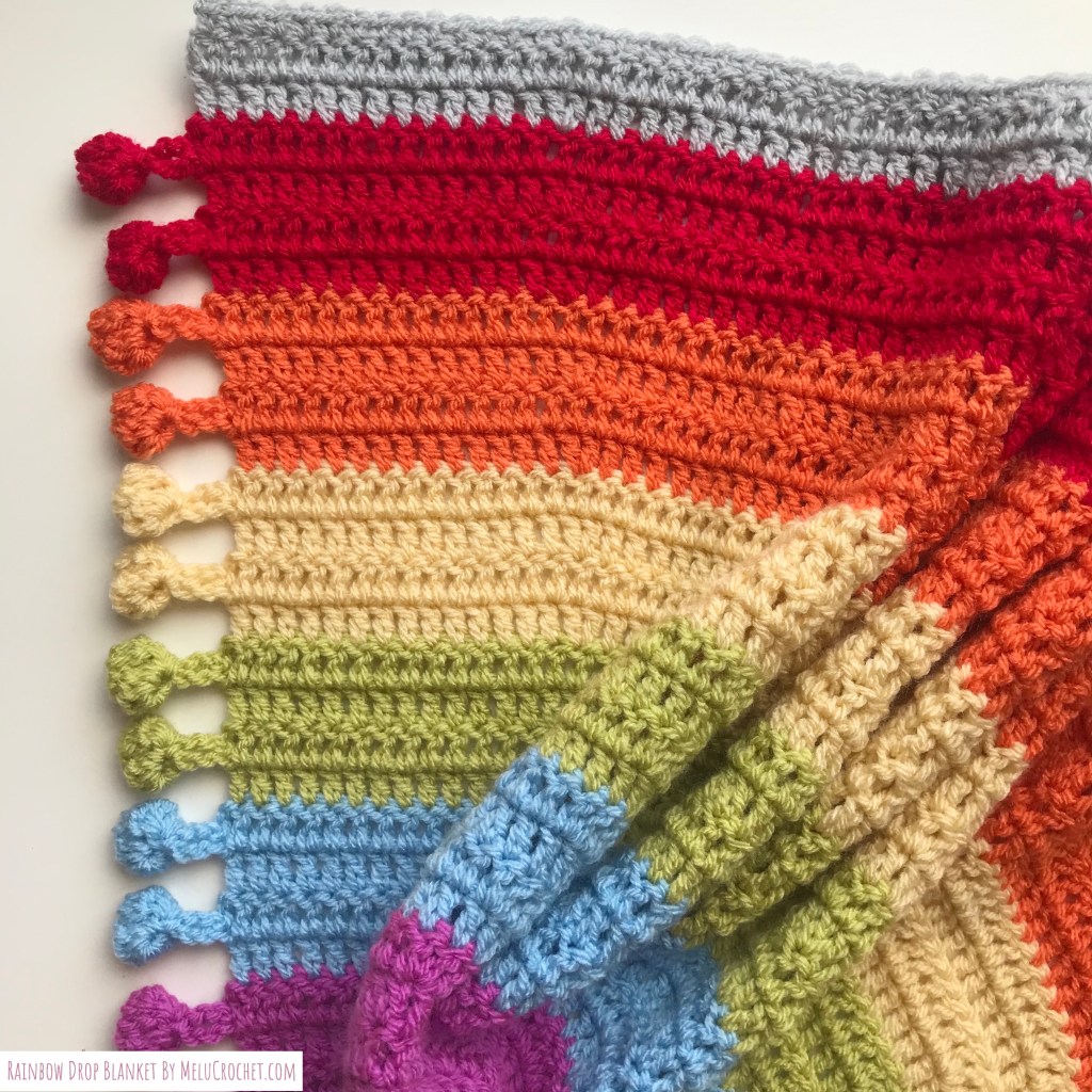 Zoomed in Rainbow shaped blanket with bobble pom pom fringe
