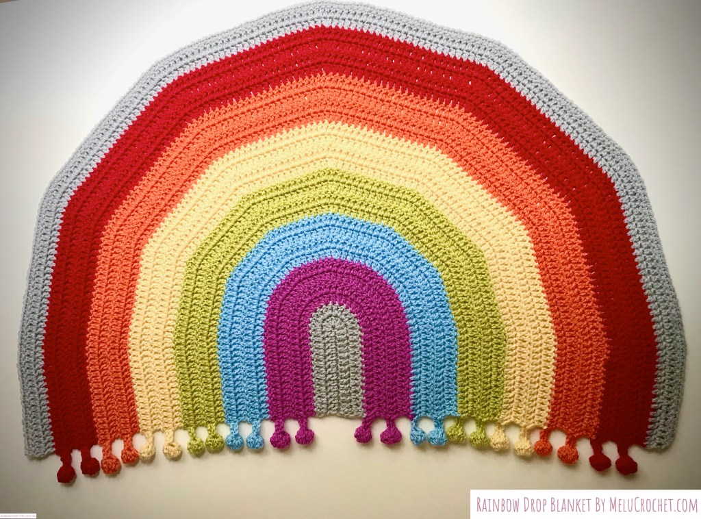 Rainbow shaped blanket with bobble pom pom fringe